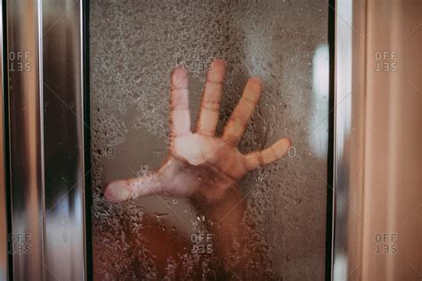 Hand Of Girl Pressed Up Against Glass Door Of The Shower Stock Photo