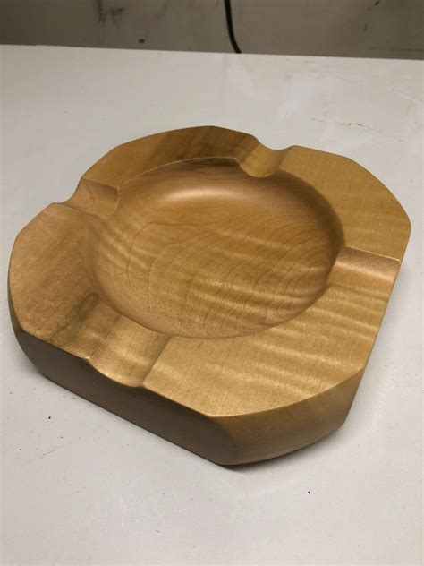 A Wooden Bowl Sitting On Top Of A White Table