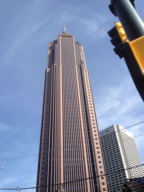 A Tall Building With A Yellow Traffic Light In The Foreground And Other