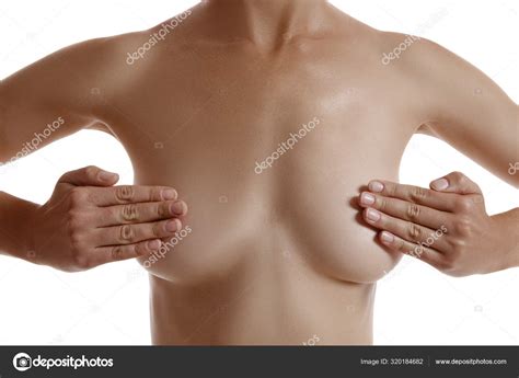 Cuerpo perfecto y desnudo de una niña cubriendo el pecho con las manos posando aislada sobre