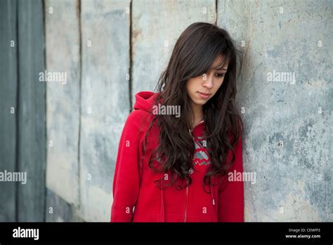 Teenage Girl Leaning Against Grunge Wall With Expression Of Sadness