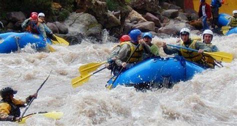 A Group Of People Riding On Top Of Rafts Down A River Filled With White
