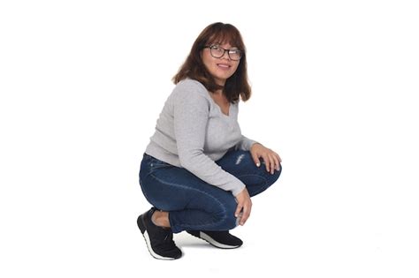 Premium Photo Woman Squatting And Looking At Camera On White Background