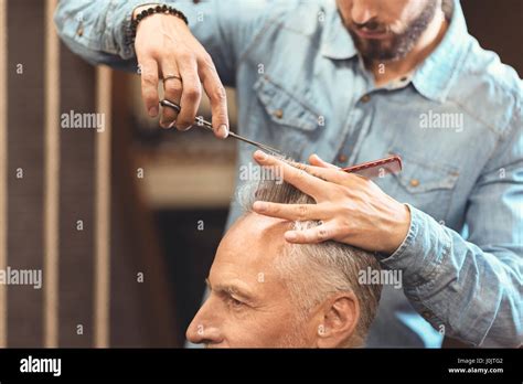 Crafty young master designing haircut in the salon Stock Photo - Alamy