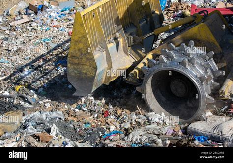 Close Up Of Bulldozer Working On Huge Landfill Or Garbage Dump Pile