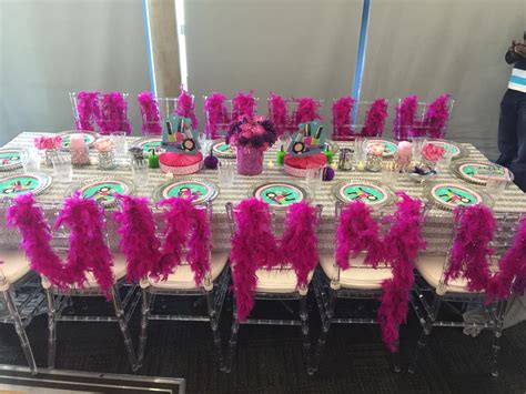 A Table Set Up For A Party With Pink And Green Decorations On Top Of It