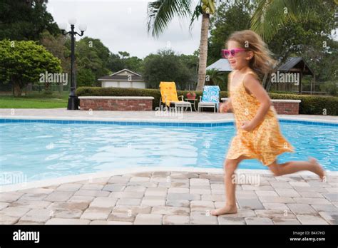 Girl Running Beside Swimming Pool Stock Photo Alamy