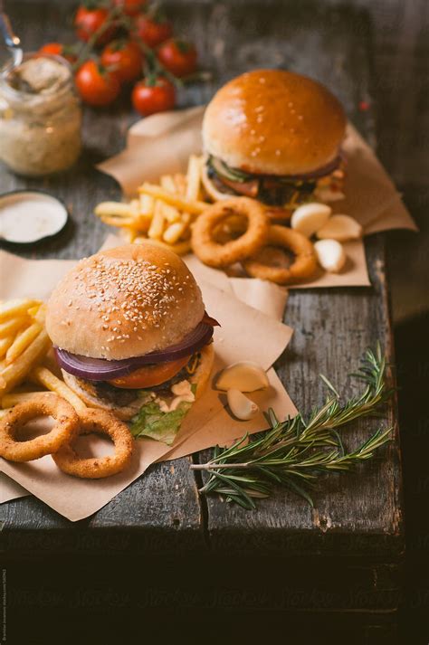 Hamburgers With Fries And Onion Rings On The Rustic Table Stock Image