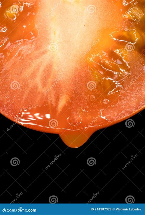 A Drop Of Juice Dripping From A Fresh Tomato Cut In Half Stock Photo