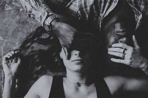 Black And White Of Interracial Couple On Ground Covering Each Others Eyes By Phil Chester