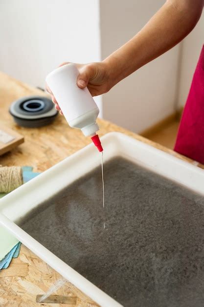 Free Photo Womans Hand Pouring Glue In Pulp For Making Paper