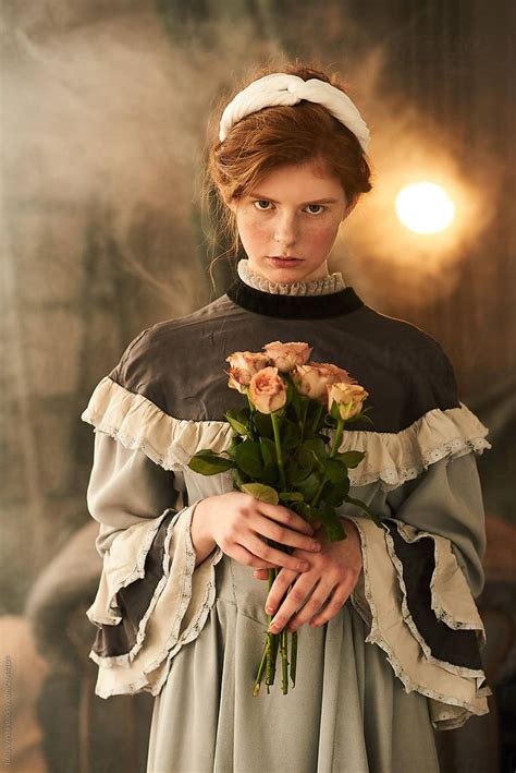 A Portrait Of A Beautiful Woman Dressed In An Old Dress Holding Roses