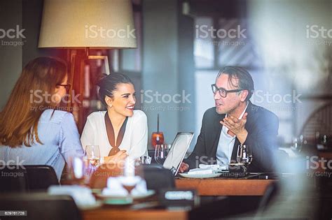 Group Of Friends Enjoy Chatting During Lunch Time At Restaurant Stock