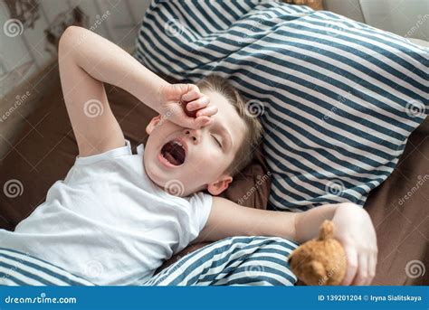 Close Up Face Of Kid Yawning And Holding Teddy Bear Sleepy Child