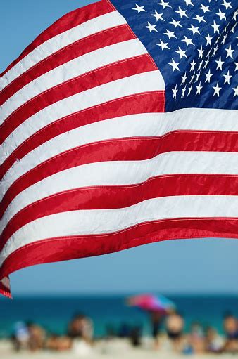 American Flag Flying Over Bright Beach Scene Stock Photo Download