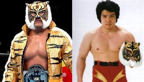 Two Men In Wrestling Costumes One With A Tiger Mask And The Other Without