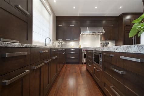 These chocolate brown cabinets create a very smooth look and so does the minimal hardware. 8 Best Hardware Styles For Shaker Cabinets