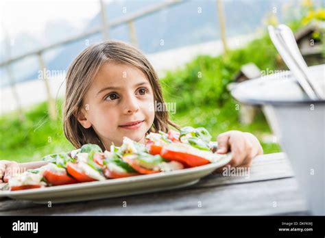 Young Girl Holding Salad Plate For Picnic Lunch Tyrol Austria Stock
