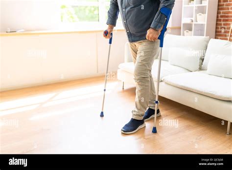 Disabled Man Using Crutches To Walk At Home Stock Photo Alamy