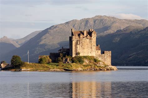 An Old Castle Sitting On Top Of A Small Island In The Middle Of A Lake