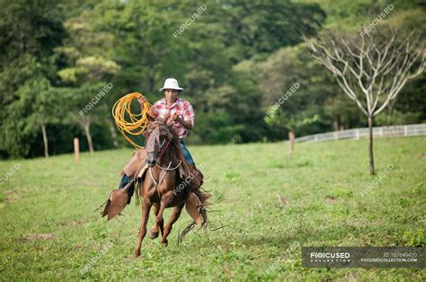 Man With Lasso Riding Horse In Field — Only Male Day Stock Photo