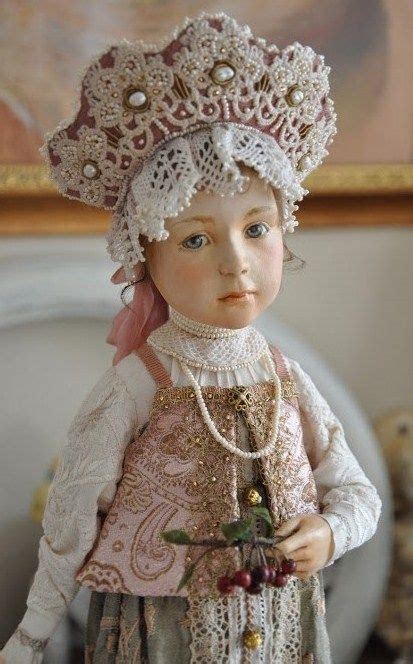 The Doll Is Wearing A Dress And Hat With Pearls On Its Head