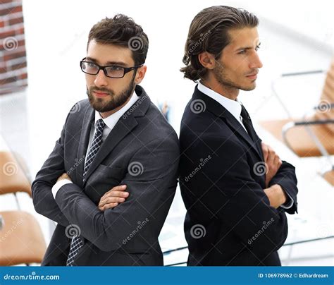 Two Men Standing Back To Back And Support Each Other Stock Photo