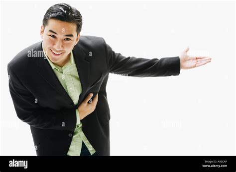 Asian Man Bowing With Arm Out Stock Photo Alamy