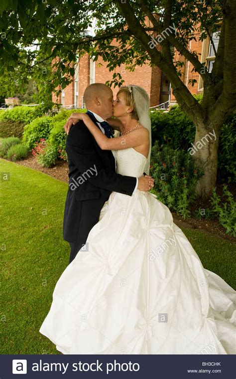 A Newly Married Couple A Bride And Groom Kiss And Embrace In The