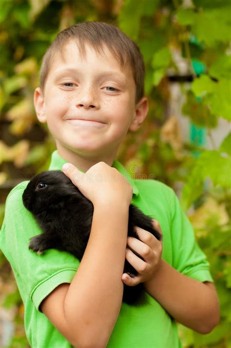 Little Boy With A Rabbit In His Hands Stock Photo Image Of Boys Lawn