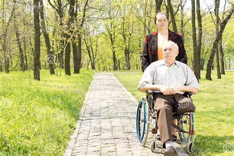 Gehende Frau Ein Behinderter Mann In Einem Rollstuhl Stockbild Bild