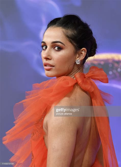 A Woman In An Orange Dress Poses For The Camera