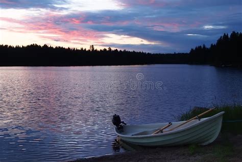 Sunset On The Lake With Fishing Boat On The Shore In Finland Stock
