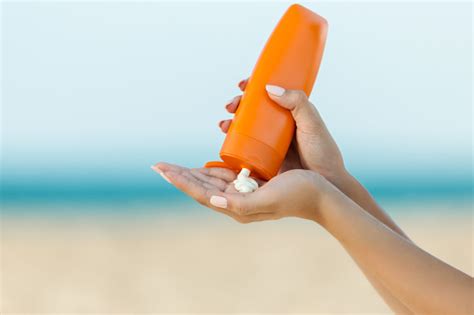 Woman Hand Apply Sunscreen On The Beach Stock Photo Download Image