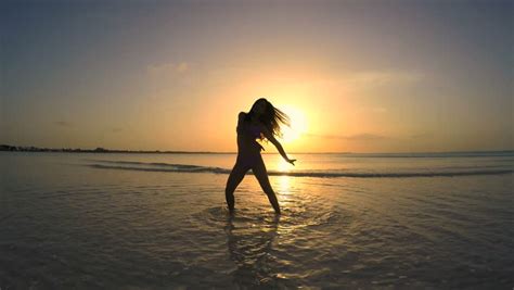 Girl During Twilight Moment. Young Woman Dancing At Beach ...