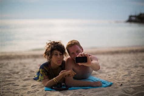 Couple Taking A Selfie On The Beach By Stocksy Contributor Mosuno Stocksy