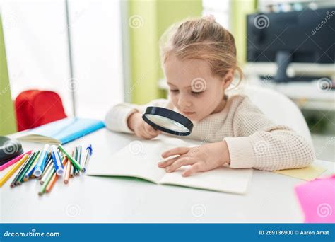Adorable Estudiante Rubia Leyendo Libro Usando Lupa En El Aula Foto De