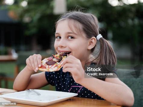 Photo Libre De Droit De Fille Heureuse Denfant Mangeant Sa Tranche De Pizza Dans Le Restaurant