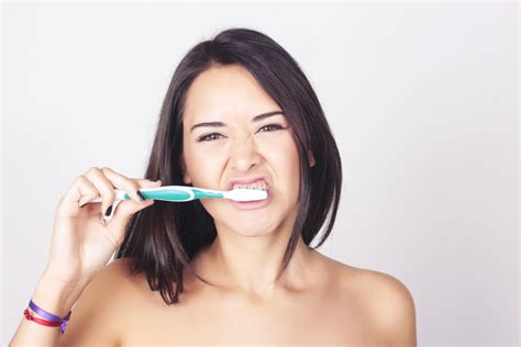 Young Woman Brushing Her Teeth Isolated Over White Background Unique Smiles Dental Practice