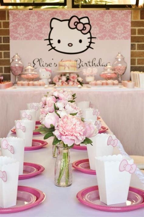 There Is A Table Set With Pink Flowers And Hello Kitty Napkins On The Table