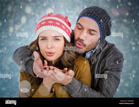Couple Blowing Kisses Against Blue Bokeh Background Stock Photo Alamy