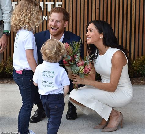 Meghan is seen cradling her baby bump in a flowing dress, by carolina herrera, one she previously wore when pregnant with archie. BABY BUMP: Pregnant Meghan says she and Harry can't wait ...