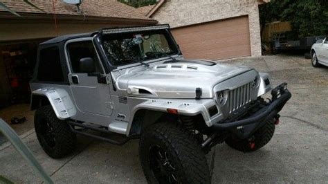 A Silver Jeep Parked In Front Of A House