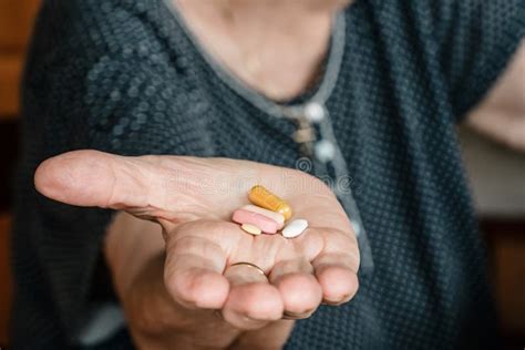 Elderly Senior Woman Hand Holding Five Different Pills Or Meds Stock