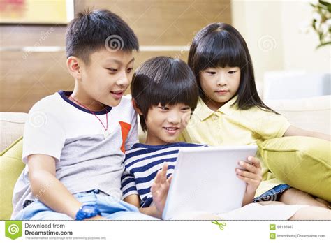 Three Asian Children Using Digital Tablet Together Stock Image Image