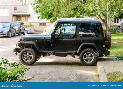 Side View Of Two Door Black Jeep Wrangler Parked On An Outdoor Parking