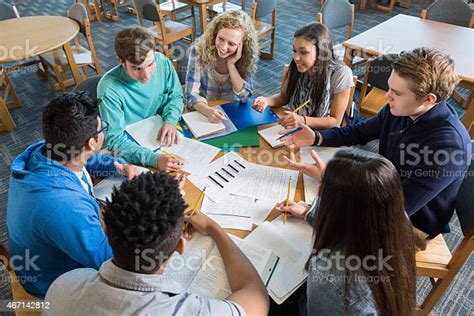 Large Diverse Group Of Students Studying Together In Library Stock