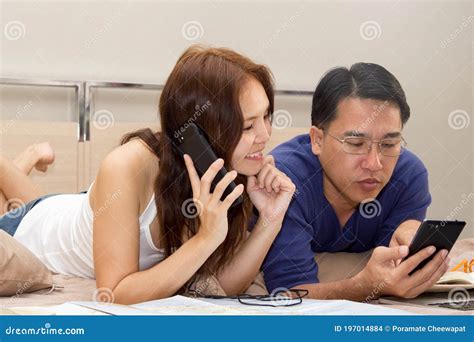 Asian Mature Couple Look At Smartphone And Booking Hotel For Holidays