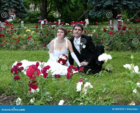 Couple About To Get Married Holding Hands With A Flower Bouquet Stock