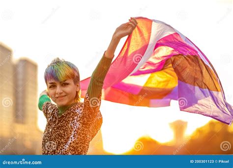 Portrait Of Happy Non Binary Person Waving Gender Fluid Flag Stock
